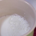 Espuma de leite à mão para um cappuccino