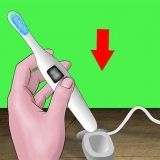 Usando uma escova de dentes elétrica