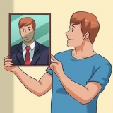 Organize fotos emolduradas em uma parede
