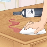 Tirar vinho tinto de um piso ou mesa de madeira