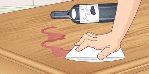 Tirar vinho tinto de um piso ou mesa de madeira